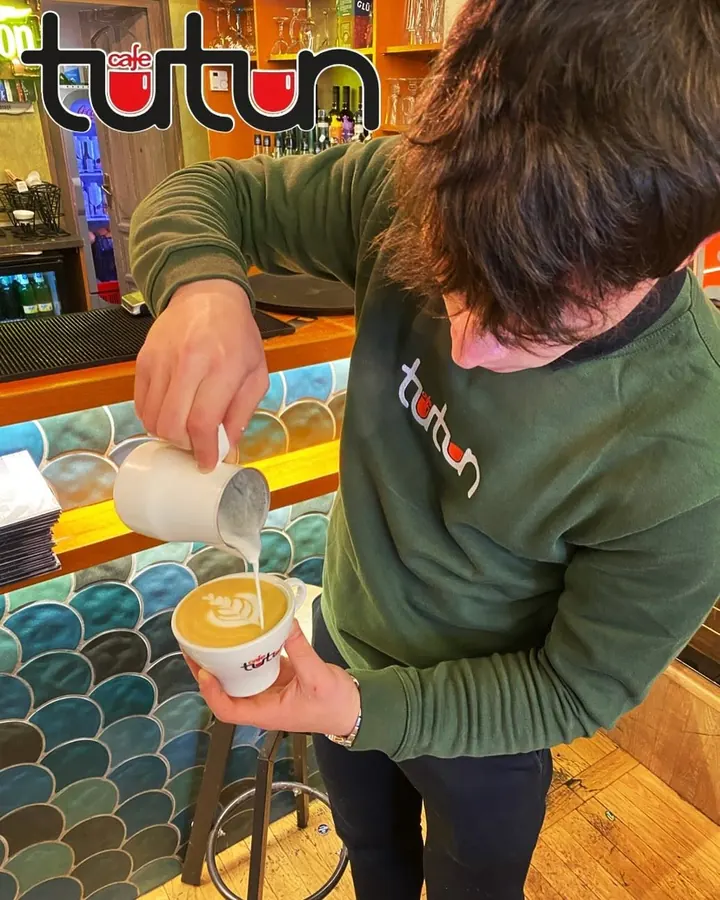 Barista Tutun turnând latte art